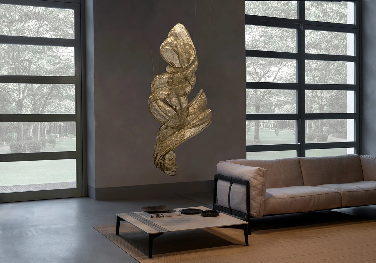 Genesis Vertical Floating Knit Sculpture by Terzani in brass, suspended in a contemporary living room.